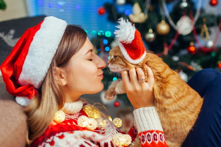Une femme et son chat célèbrent Noël ensemble.