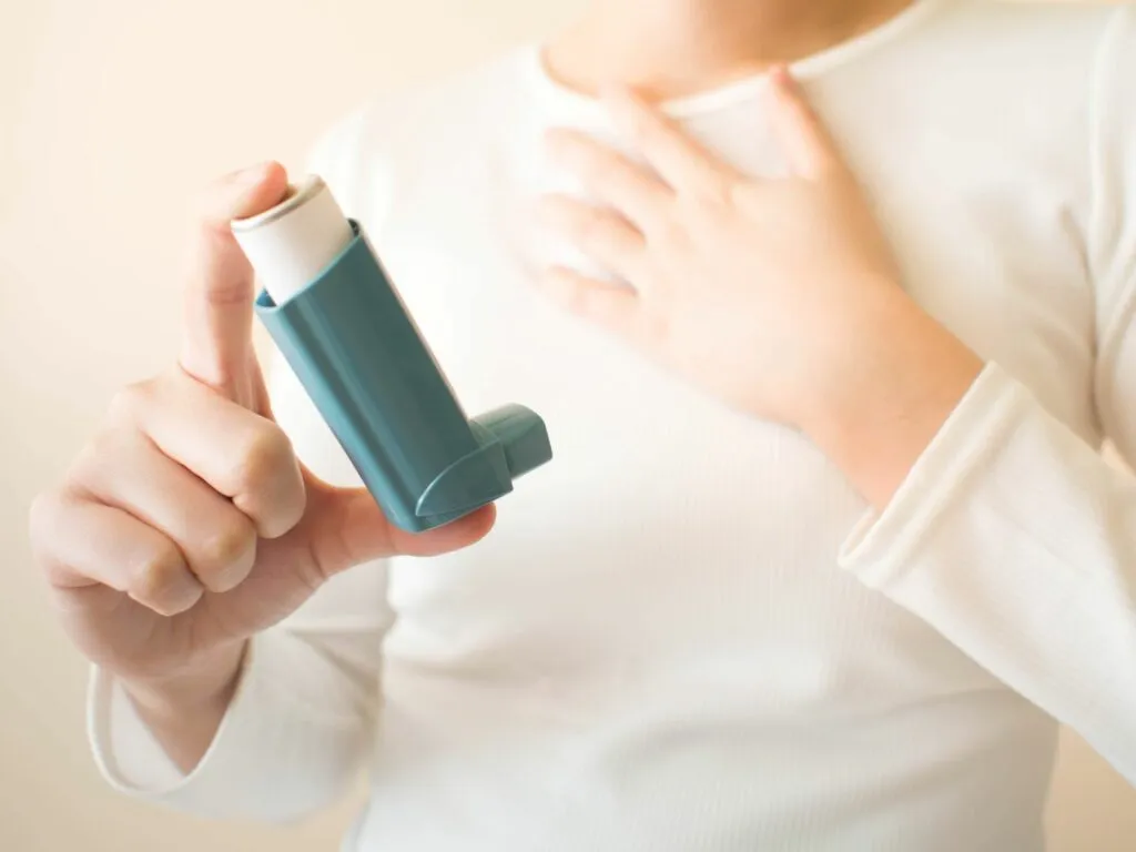 Un enfant tient un inhalateur