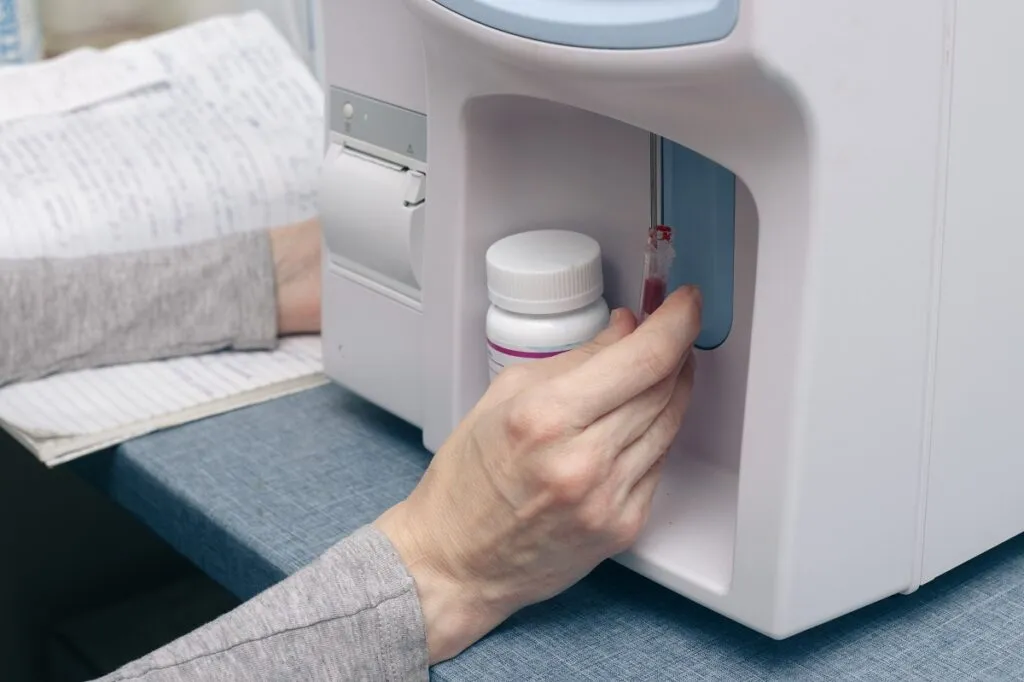 Un vétérinaire place un echantillon de sang dans une machine pour l'analyser